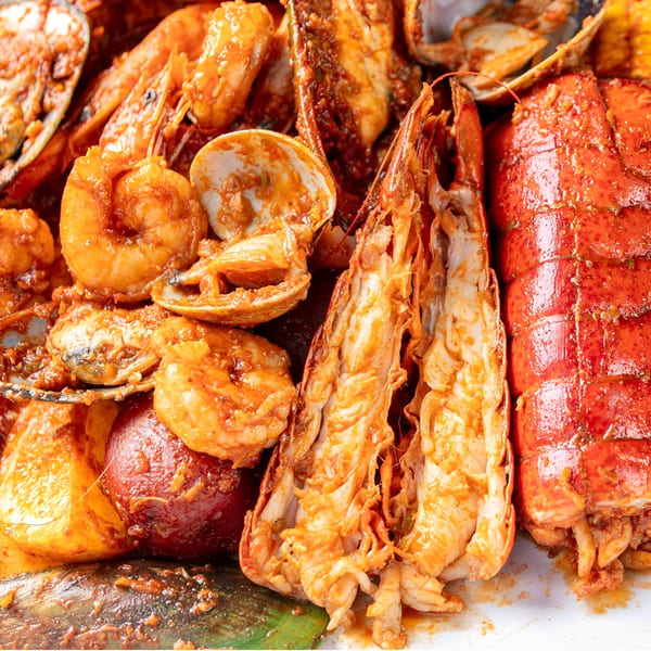 Close-up of a Boil Daddy seafood boil with lobster, shrimp, clams, and potatoes.